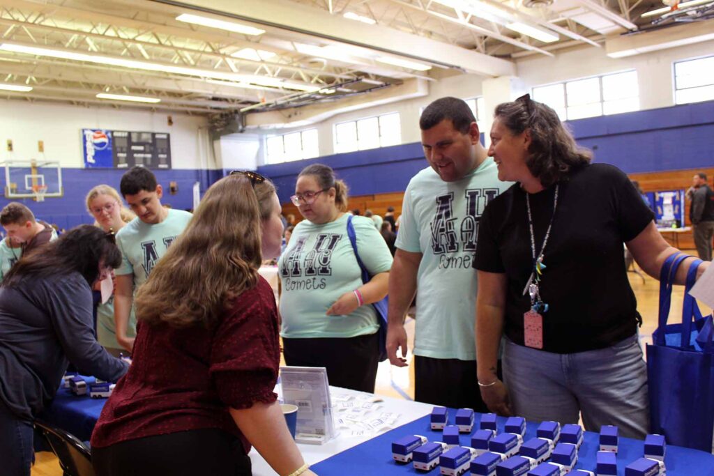 Students speak with Goodwill employees at an information table.