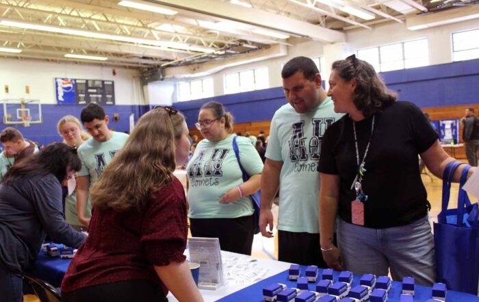 Students speak with Goodwill employees at an information table.