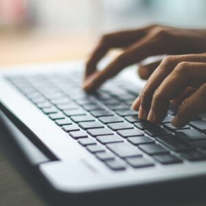 Photo of an individual typing on a laptop