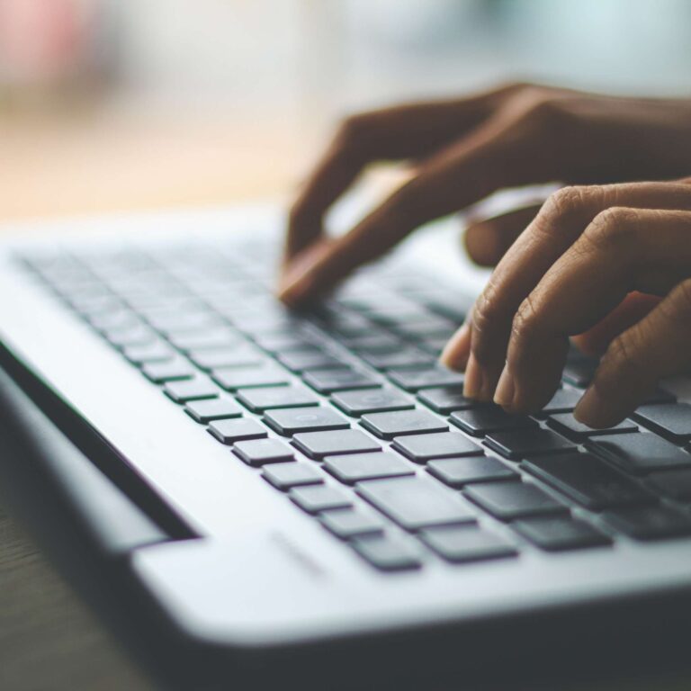 Photo of an individual typing on a laptop