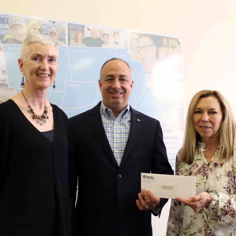 A group of individuals gather and a check is presented.
