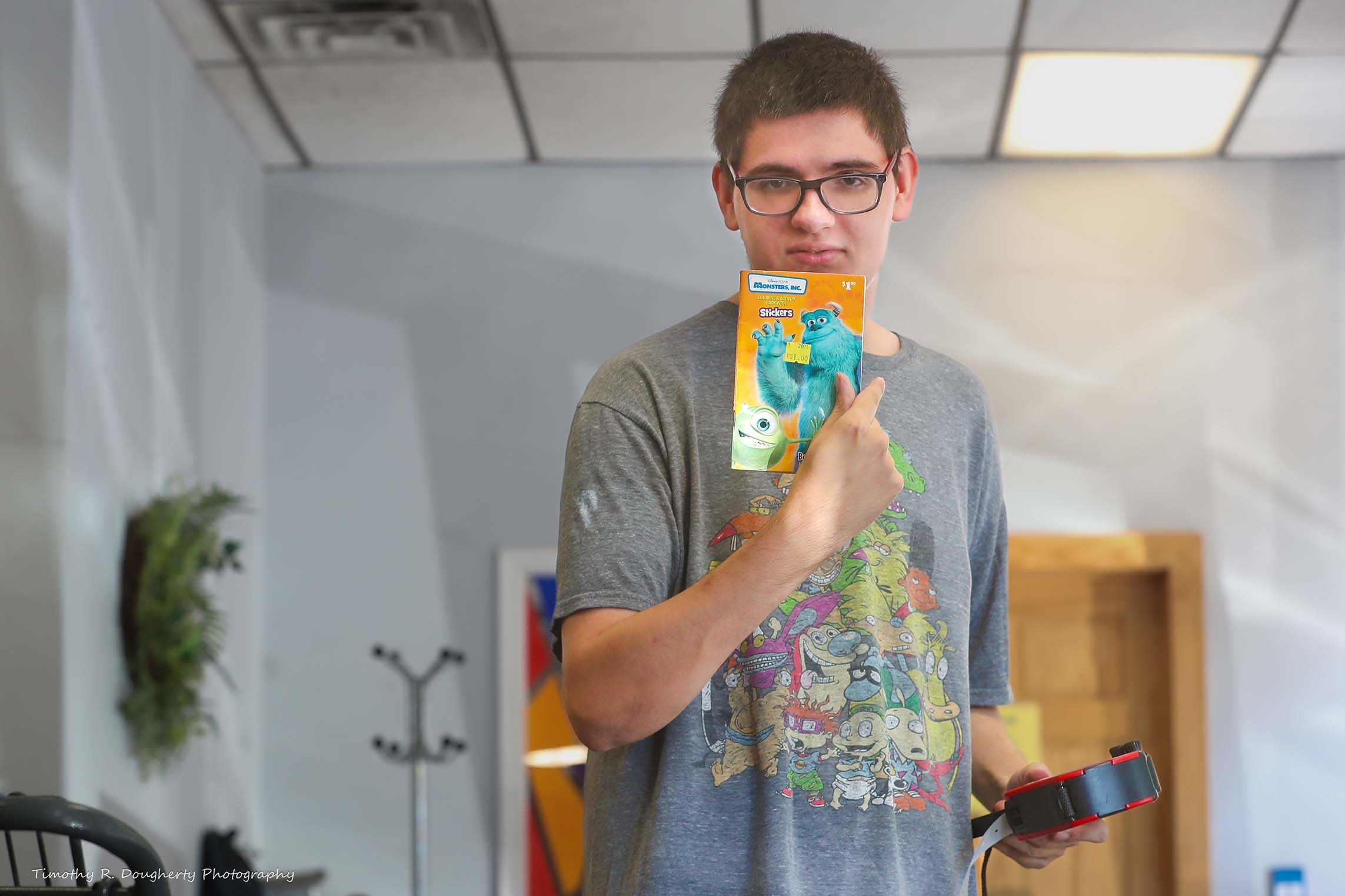 A young man holds a sticker book
